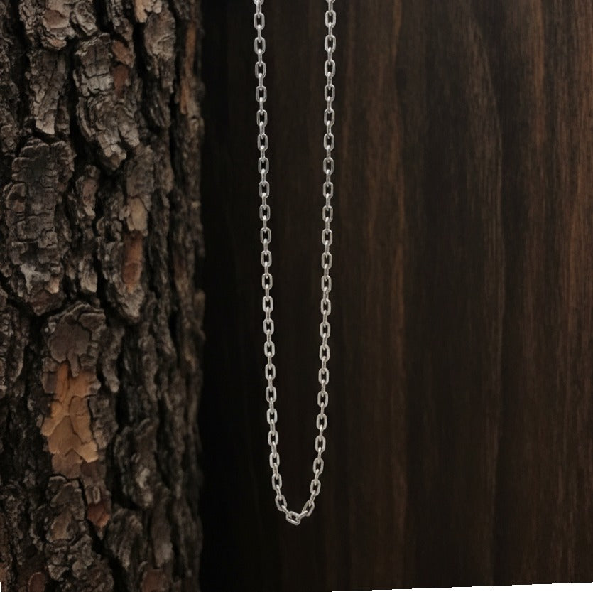 Silver chain necklace against a wooden background
