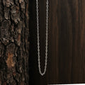 Silver chain necklace against a wooden background