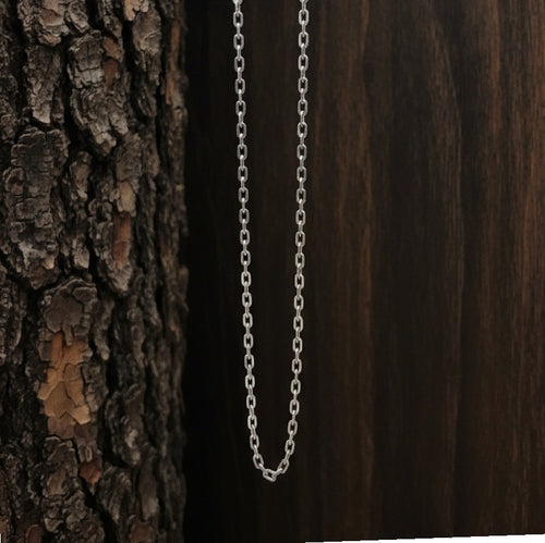Silver chain necklace against a wooden background