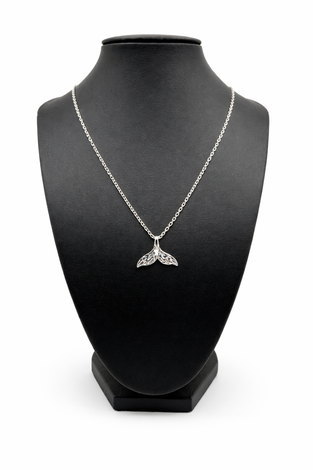 Silver necklace with a whale tail pendant on a black mannequin bust.